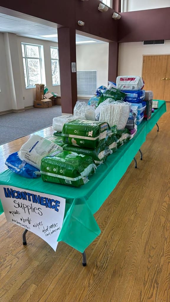 Many packages of adult briefs on a table at the swap
